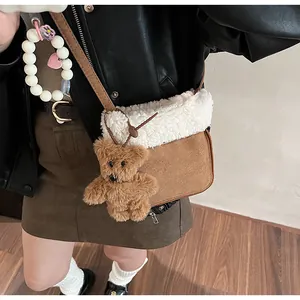 Detail of brown suede and white fleece crossbody bag featuring a cute bear plush pendant