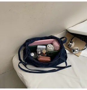 Detail view showing large storage capacity of the blue denim bag with daily essentials