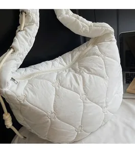 Détail macro du motif de cœur matelassé blanc sur un sac à bandoulière souple