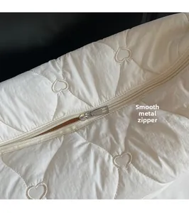 Gros plan du tissu matelassé en forme de cœur et fermeture éclair en métal argenté