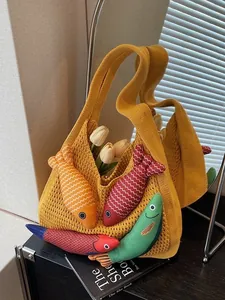 Yellow knit tote bag with colorful cartoon fish charms and tulips in a bright home setting