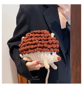 Gros plan d'un sac bandoulière hérisson au crochet porté sur un blazer noir chic
