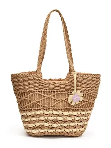 Grande borsa tote in paglia intrecciata con design traforato e ciondolo floreale beige