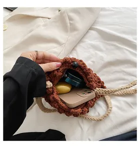 Vue intérieure du sac crocheté marron montrant l'espace pour téléphone et maquillage