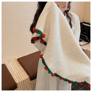 Detail of white knit shawl featuring handmade 3D red strawberry and green leaf crochet fringe