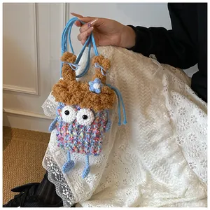 Détail d'un sac bandoulière monstre au crochet bleu fait main avec texture tricotée