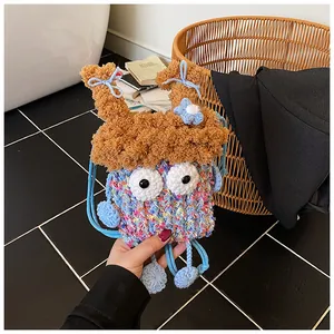 Détail d'un mini sac bandoulière au crochet fait main avec de grands yeux et nœuds bleus