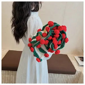 Detail of handmade crochet blanket with 3D red roses and green stems on white wool