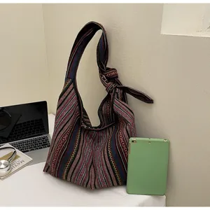 Detail of colorful striped woven hobo bag with large capacity and knot shoulder strap