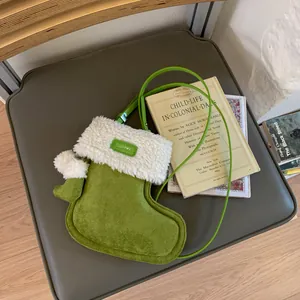 Cute green faux suede Christmas stocking shaped crossbody bag with plush white trim details