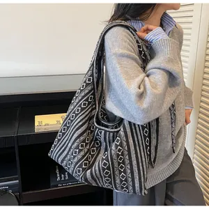 Close-up of ethnic knit tote bag showing black and white geometric patterns and textures