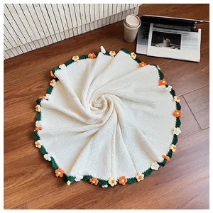 Close-up of handmade crochet rose bouquet blanket with floral edges on wooden floor