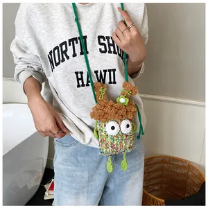 Détail du sac monstre crocheté main avec yeux de dessin animé et bandoulière verte