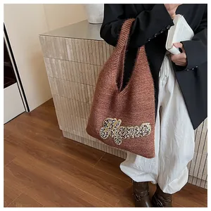 Detalle del bolso tote de punto con aplique de Mama en leopardo y correa al hombro