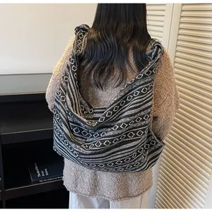 Detailed view of the knotted shoulder strap on a bohemian geometric woven tote bag