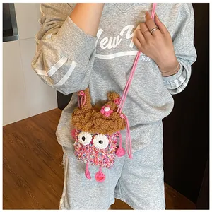 Détail d'un sac monstre au crochet rose avec yeux de dessin animé et fleurs