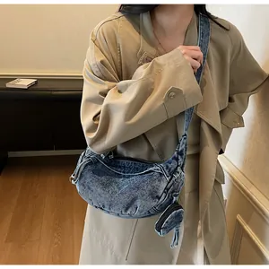Dettaglio della borsa a tracolla in denim vintage con portamonete rotondo su un modello