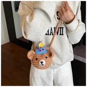 Close-up of hand-knitted brown bear crossbody bag with detailed crochet texture and star
