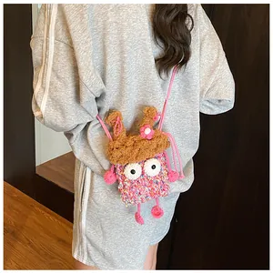 Détail d'un sac à bandoulière au crochet avec yeux de dessin animé et fleurs