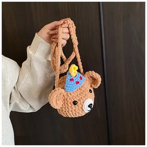 Macro view showing handcrafted brown knit bear coin purse with blue party hat detail