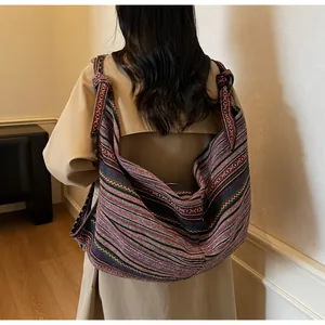 Ethnic bohemian woven shoulder bag with colorful stripes and decorative knotted strap