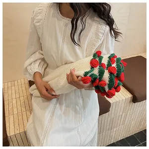 Detail of a handmade knitted red rose bouquet paired with a white lace vintage dress
