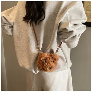 Detailed view of a soft brown plush bear crossbody bag with a slim strap on a model