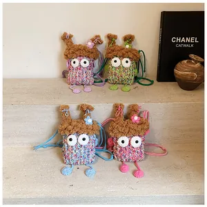 Détail de mini sacs monstre au crochet colorés avec texture en laine et grands yeux décoratifs