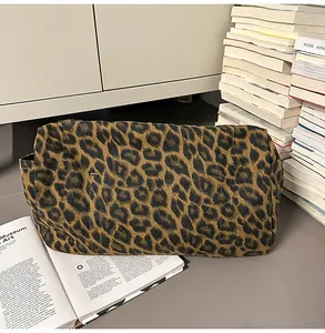 Detail of leopard print canvas tote bag featuring side pockets and textured fabric material