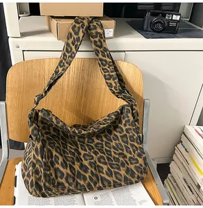 Detail shot of leopard print hobo bag with adjustable wide strap on a wooden chair
