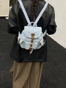 Vintage light blue floral denim backpack with brown leather straps and beaded chain