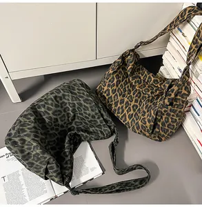 Detail of leopard print canvas bags with adjustable straps in brown and dark green colors