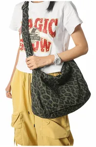 Detail of leopard print canvas bag with wide strap and spacious crescent shape design