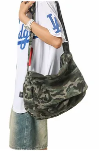 Detail of large camo canvas messenger bag with adjustable strap and durable texture