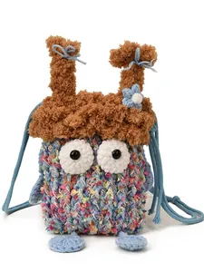 Sac à bandoulière en crochet fait main avec yeux mignons et nœuds bleus sur fond blanc