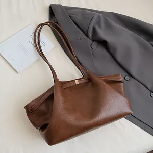Détail du grand sac cabas marron foncé en cuir avec bandoulière et boucle métallique