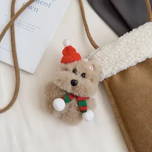 Détail d'un charme d'ours en peluche avec bonnet rouge sur un sac en daim marron