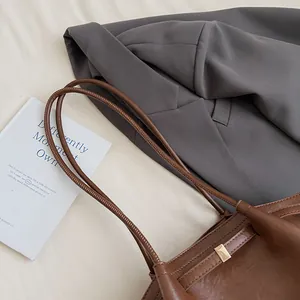 Détail du sac cabas marron foncé en similicuir avec boucle dorée et fines lanières