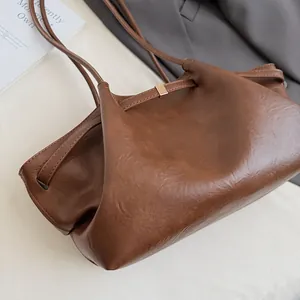 Détail du cabas en cuir PU marron avec texture brillante et fermeture en métal doré élégante