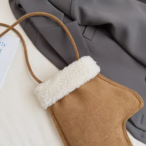 Détail du sac à bandoulière en daim marron avec bordure en peau lainée blanche