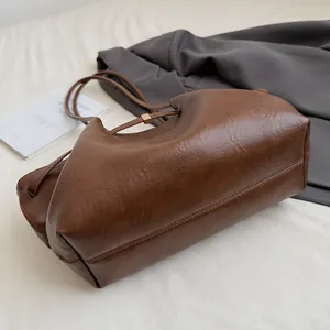 Gros plan du grand sac cabas vintage marron avec texture plissée et boucle en métal
