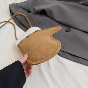 Détail du mini sac bandoulière en daim en forme de gant avec bordure en fourrure