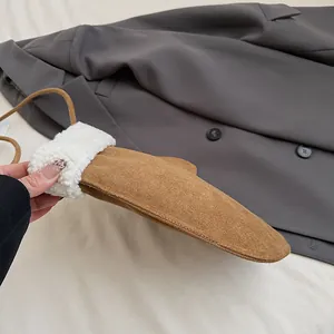 Détail d'une moufle en daim marron avec bordure en polaire blanche et cordon de cou