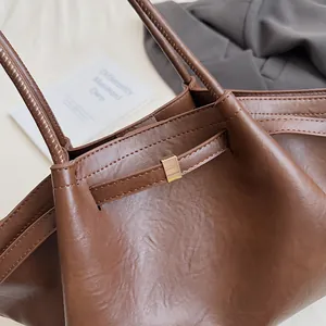 Gros plan détaillé du cabas vintage marron avec cuir texturé et boucle dorée élégante