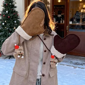 Détail de moufles d'hiver en daim avec bordure en fausse fourrure et breloques ours