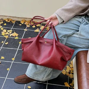 Détail d'un cabas vintage rouge foncé avec des plis élégants et une boucle en métal doré