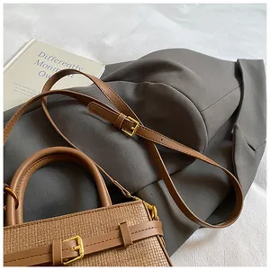 Detail of brown vintage bucket bag with woven texture on a minimalist lifestyle setting