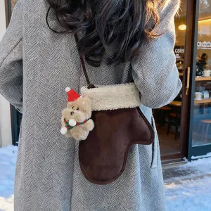 Détail du sac bandoulière en daim en forme de moufle avec bordure en fausse fourrure