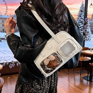 Details einer weißen PU-Leder Umhängetasche mit transparentem Fenster und kleinem Teddybären