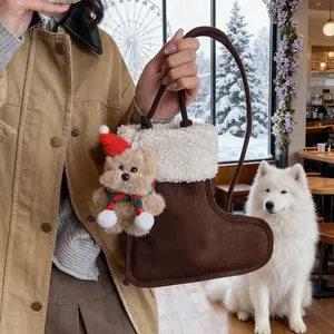Détail du sac à main en daim en forme de botte de Noël avec breloque ours et décor de neige